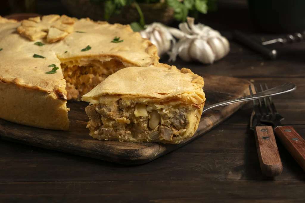 A golden-brown turkey pot pie topped with flaky puff pastry, filled with tender chunks of turkey, vibrant vegetables, and a creamy sauce, served warm and inviting on a rustic plate.