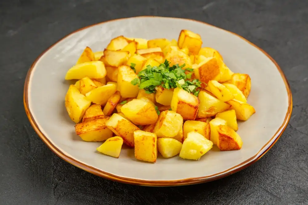 "Close-up of white sweet potato, showcasing its smooth, light-colored skin and creamy interior, placed on a rustic wooden surface."