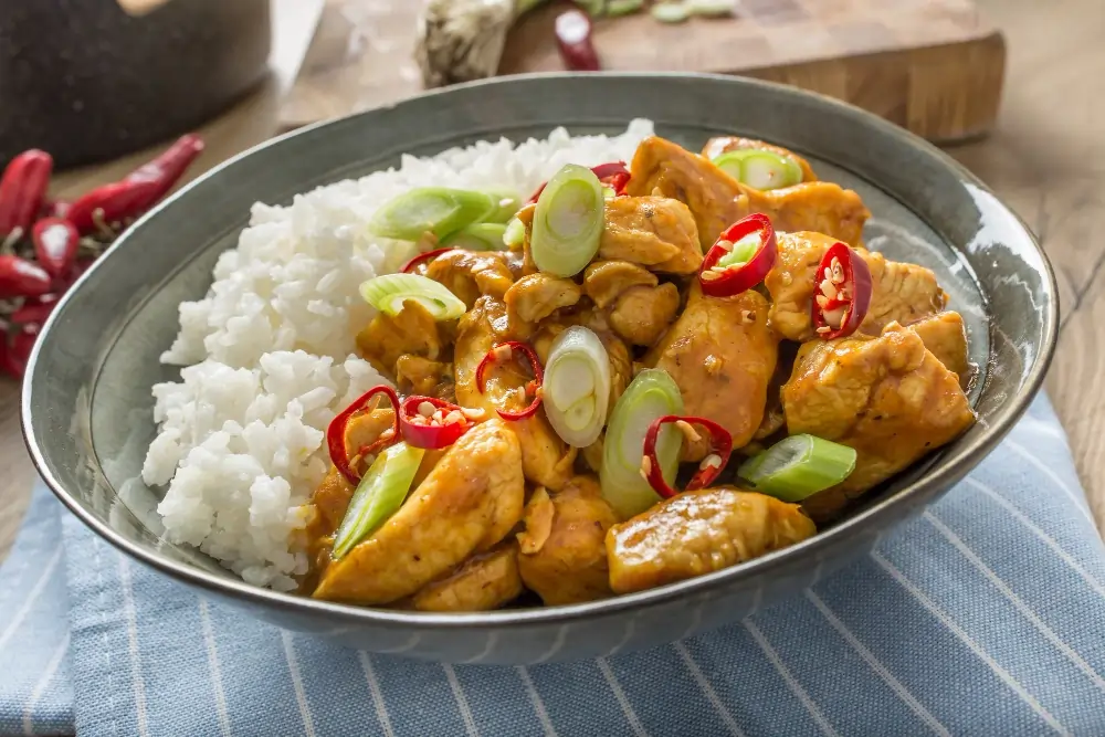 Spicy Chicken Bowl: A colorful bowl filled with tender spicy chicken, fluffy rice, fresh vegetables, and a sprinkle of herbs, showcasing a delicious and healthy meal.