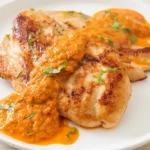 Delicious Marry Me Chicken Recipe with Creamy Sauce and Sun-Dried Tomatoes in a White Dish on a Wooden Table