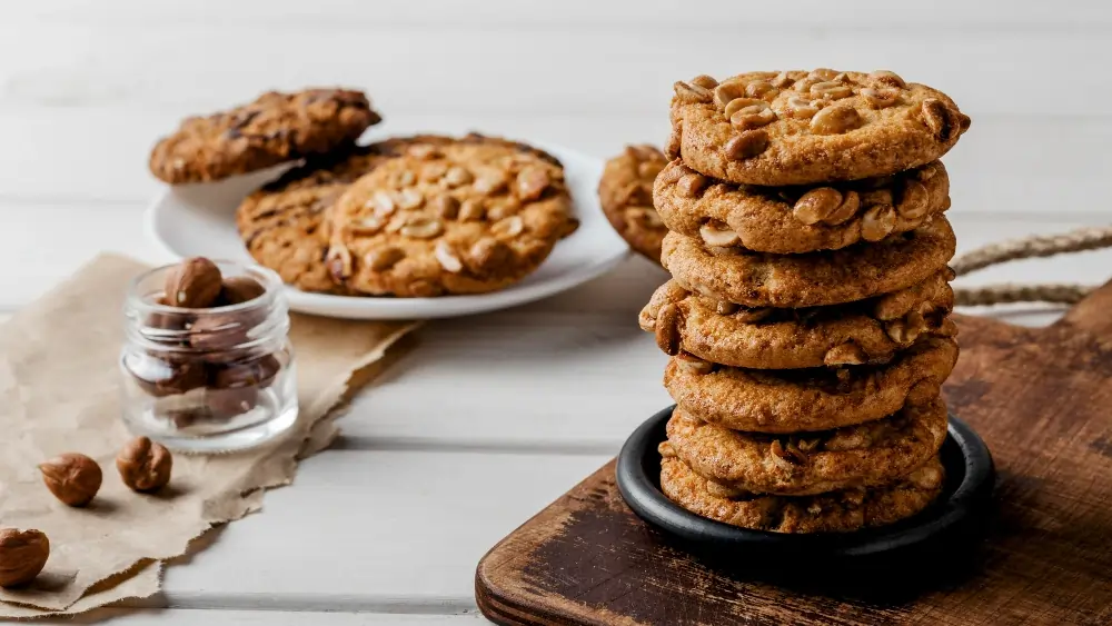 Golden-brown almond flour breakfast cookies with chocolate chips on a rustic plate, surrounded by almonds and cinnamon sticks